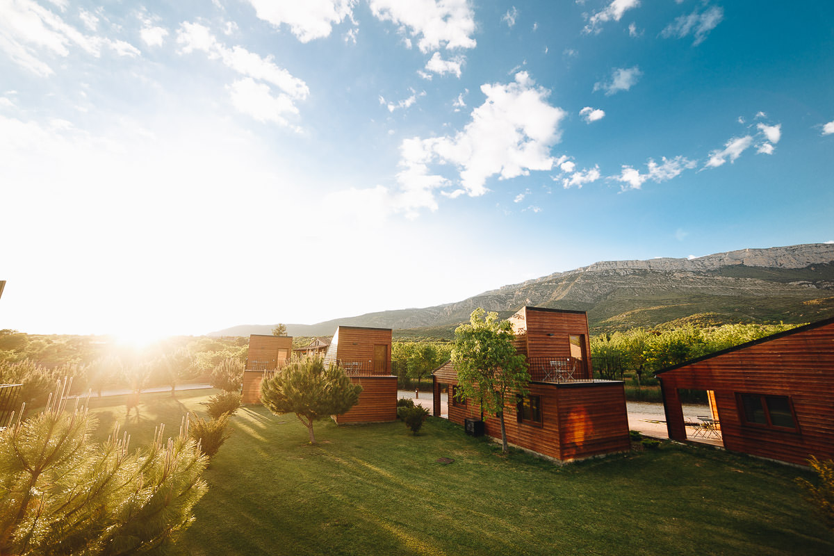 Resort Vall d'Àger bungalows in the garden at golden hour, Serra del Montsec behind