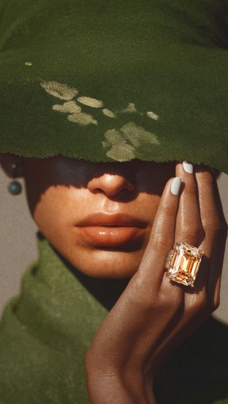 A face half-hidden, a hand with gold rings